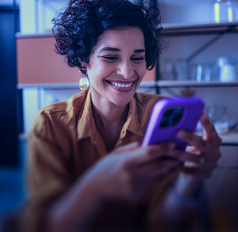 Mulher sorridente usando um celular.